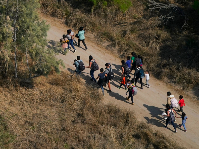 Migranten gehen im Süden von Texas über einen Feldweg, nachdem sie die Grenze zwischen den USA und Mexiko überquert haben. - Foto: Julio Cortez/AP/dpa