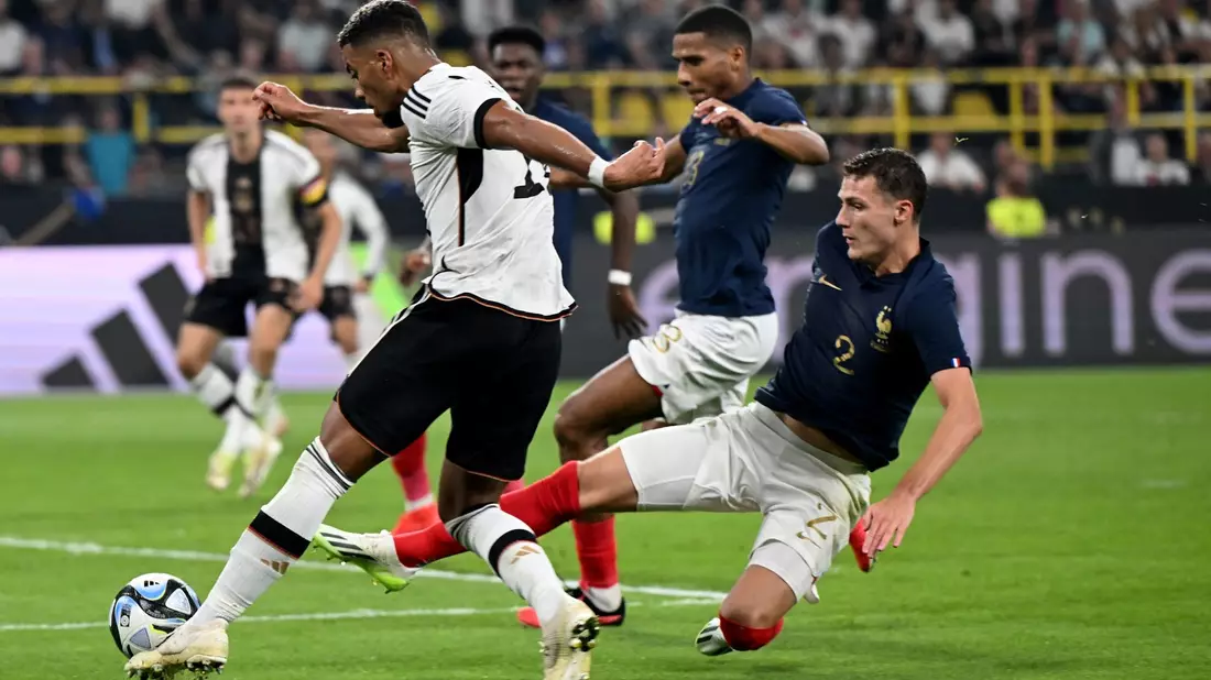 Benjamin Henrichs (l) wird von Frankreichs Benjamin Pavard attackiert. - Bild: Federico Gambarini/dpa