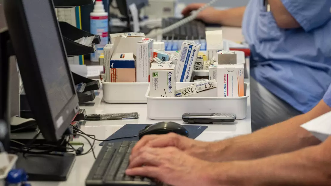 Auf einer Station im Krankenhaus stellen Pflegekräfte am Computer Medikamente zusammen. - Bild: Stefan Puchner/dpa