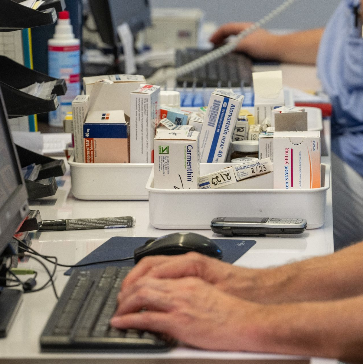 Auf einer Station im Krankenhaus stellen Pflegekräfte am Computer Medikamente zusammen. - Foto: Stefan Puchner/dpa