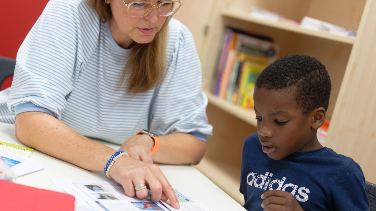 Lernhelferin Sabine Güllich unterstützt Schüler Hassan in einem Leseraum einer Grundschule in Hürth. - Foto: Henning Kaiser/dpa