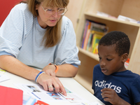 Lernhelferin Sabine Güllich unterstützt Schüler Hassan in einem Leseraum einer Grundschule in Hürth. - Foto: Henning Kaiser/dpa