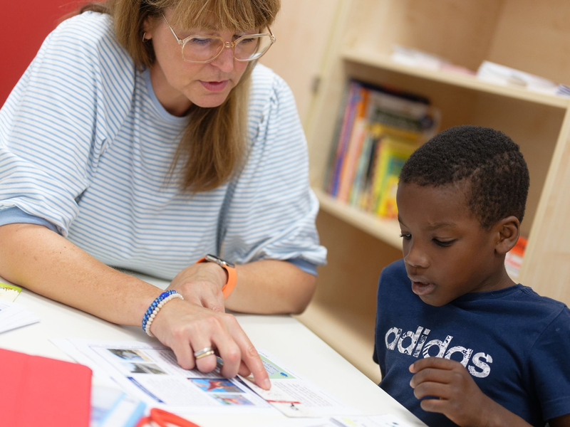 Lernhelferin Sabine Güllich unterstützt Schüler Hassan in einem Leseraum einer Grundschule in Hürth. - Foto: Henning Kaiser/dpa