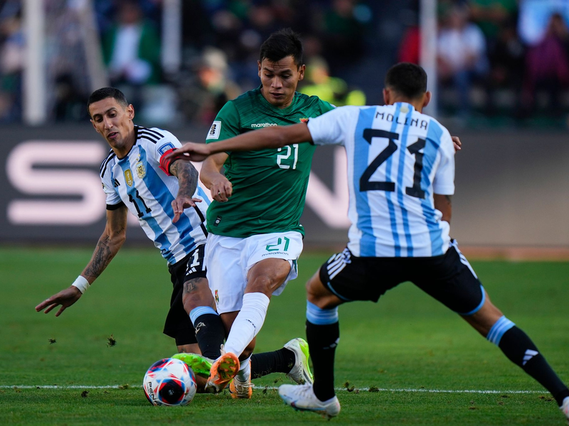Boliviens Hector Cuellar in Aktion gegen die Argentinier Angel Di Maria (l) und Nahuel Molina (21). - Foto: Juan Karita/AP