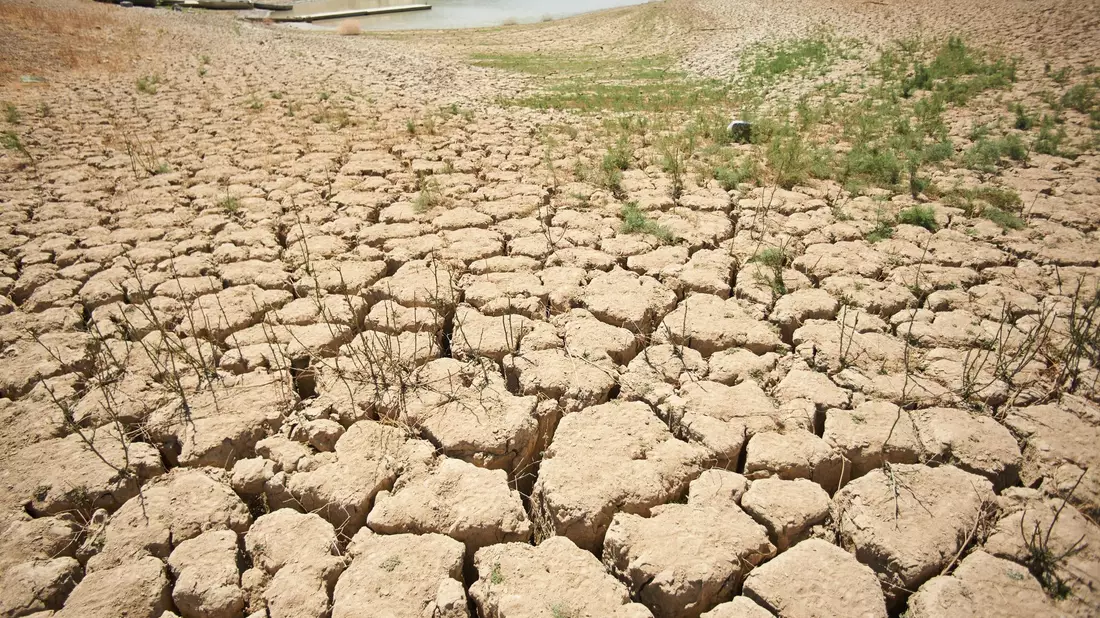Ein Symptom des schlechten Zustands der Erde: von der Trockenheit zerklüftete und aufgerissene Erde an den Ufern des Viñuela-Stausees in Spanien. - Bild: Felipe Passolas/dpa
