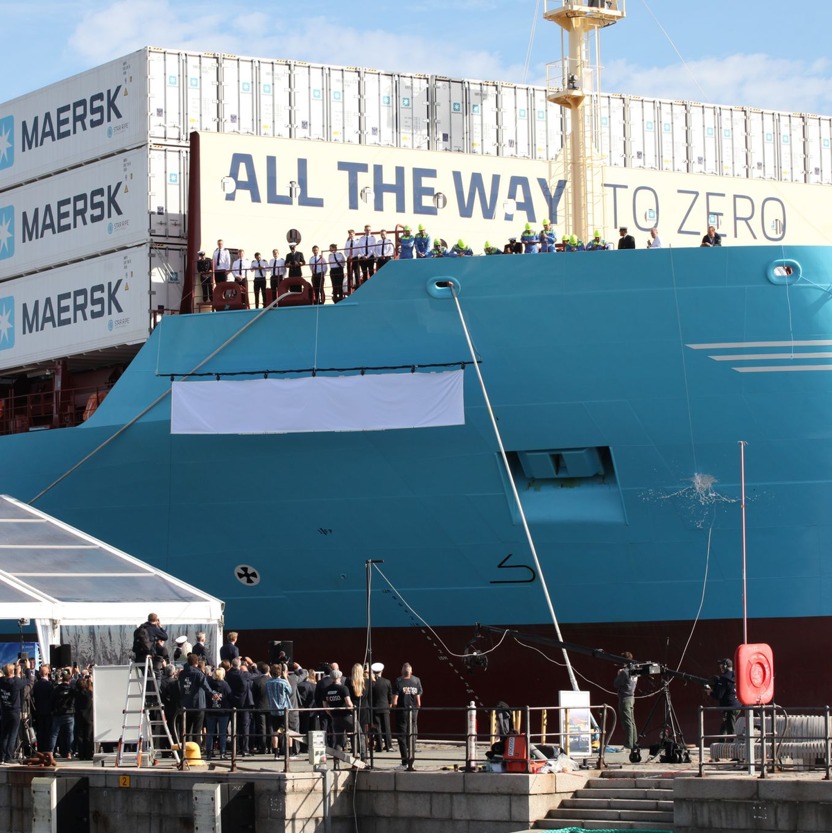 Eine Champagnerflasche zerschellt am Rumpf des weltweit ersten mit grünem Methanol betriebenen Containerschiff. - Foto: Steffen Trumpf/dpa