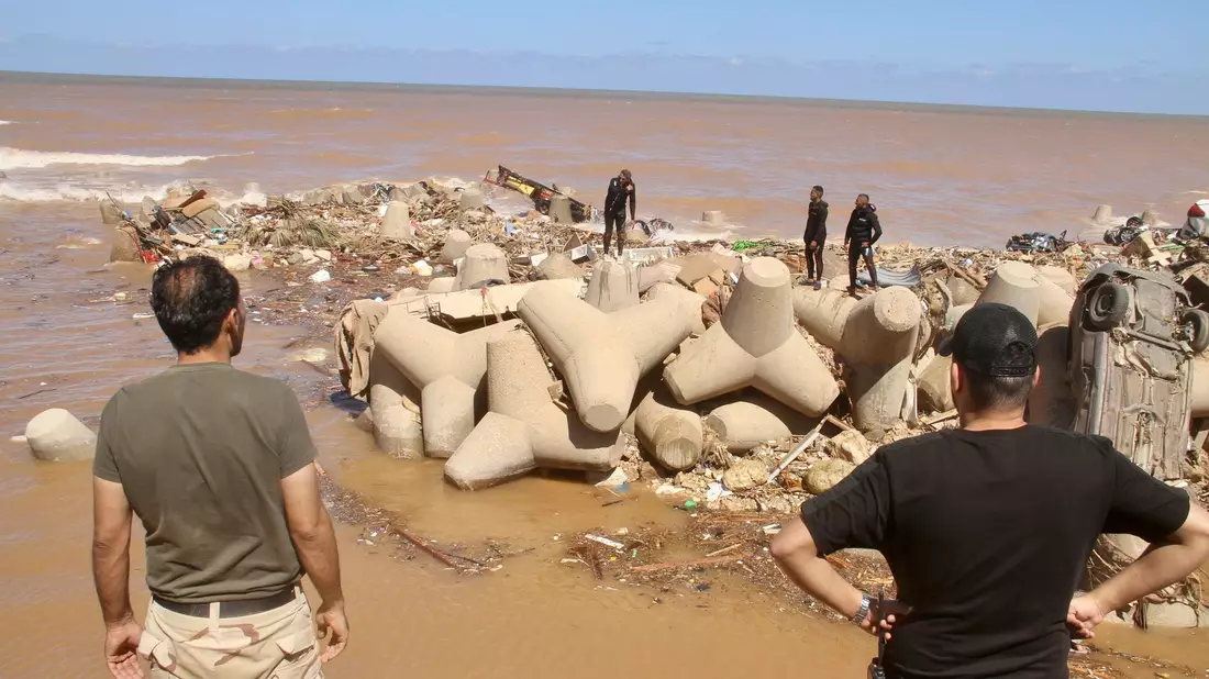Helfer begraben Opfer der Sturzflut in Libyen. - Bild: Yousef Murad/AP/dpa