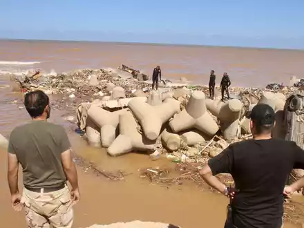 Helfer begraben Opfer der Sturzflut in Libyen. - Foto: Yousef Murad/AP/dpa