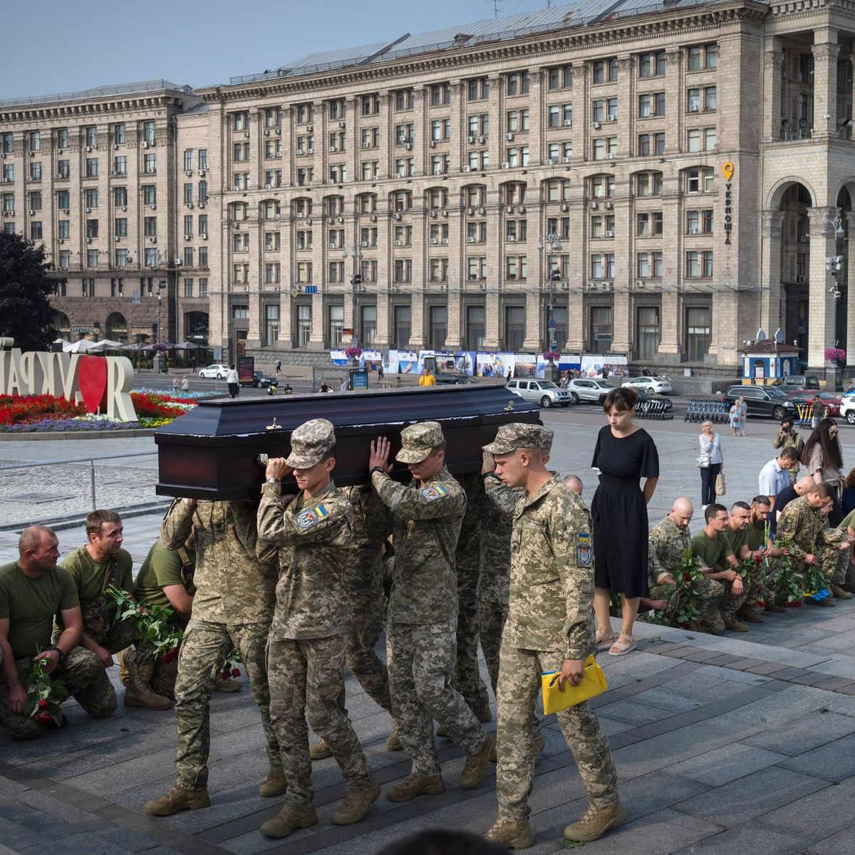 Menschen in Kiew knien nieder, während Soldaten den Sarg eines Kameraden tragen, der in einem Gefecht getötet wurde. - Foto: Efrem Lukatsky/AP/dpa