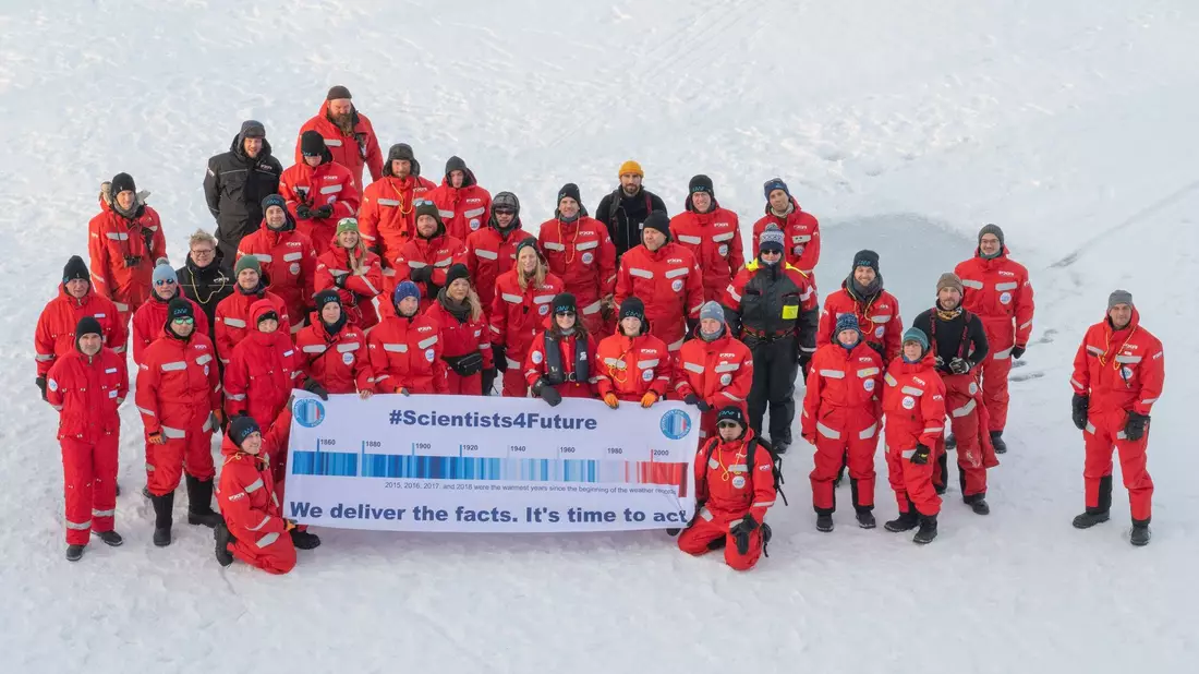 Forscher des Alfred Wegener Instituts mit einem Transparent mit der Aufschrift #Scientists4Future - We deliver the facts. It's time to act in der Arktis. - Bild: Esther Horvath/Alfred Wegener Institut/dpa