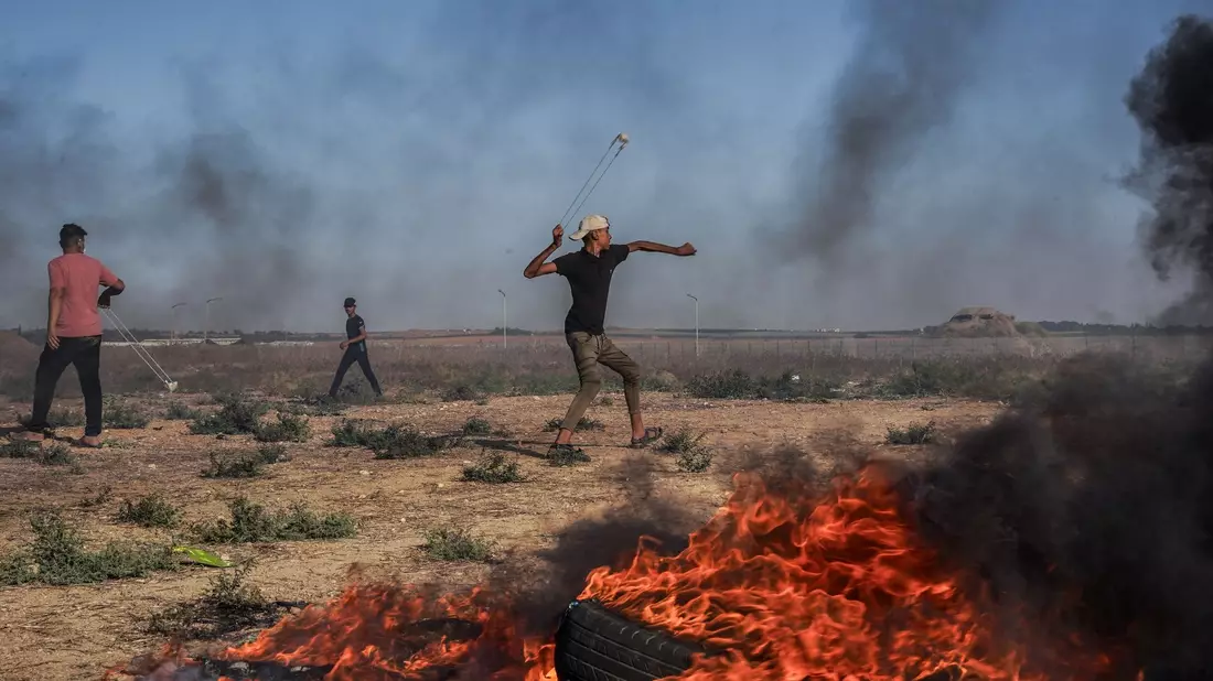 Ein palästinensischer Jugendlicher schleudert in Richtung israelischer Truppen. - Bild: Saher Alghorra/ZUMA Press Wire/dpa