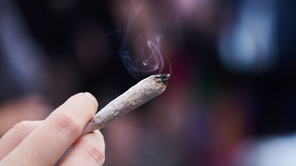 Eine Frau hält einen Joint in der Hand: Cannabis wird von der Liste der verbotenen Substanzen gestrichen. - Foto: Annette Riedl/dpa