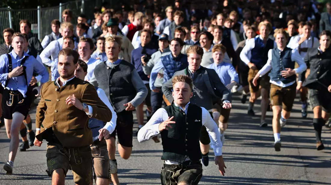 Oktoberfestbesucher stürmen nach der Eröffnung des Platzes auf die Festwiese. - Bild: Karl-Josef Hildenbrand/dpa