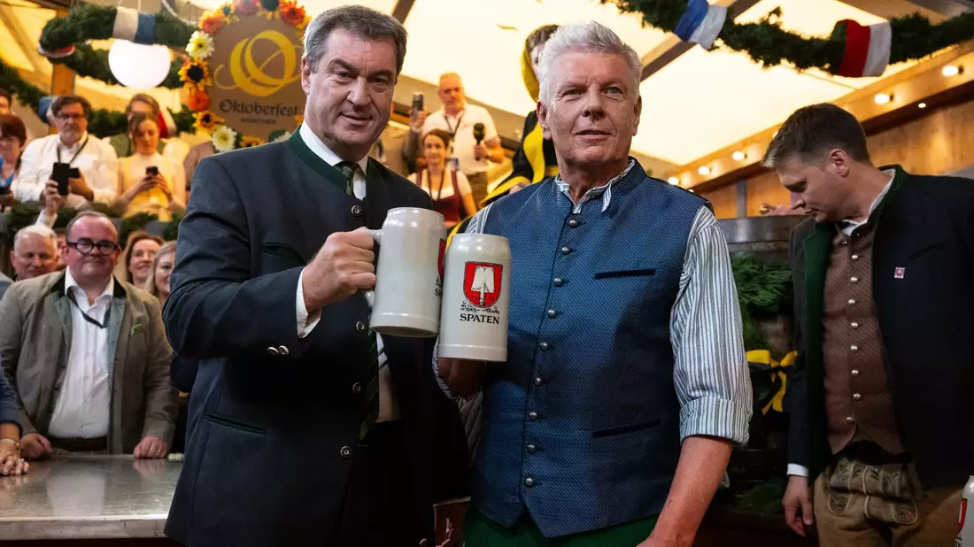 Markus Söder (l, CSU), Ministerpräsident von Bayern und Dieter Reiter (SPD), Oberbürgermeister von München, prosten sich nach dem traditionellen Fassanstich zu. - Bild: Sven Hoppe/dpa