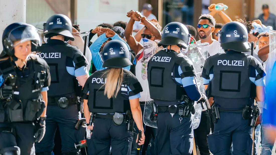 Eine Gruppe von Menschen wird nach Ausschreitungen bei einer Eritrea-Veranstaltung von Polizeikräften eingekesselt. - Bild: Thomas Niedermueller/dpa