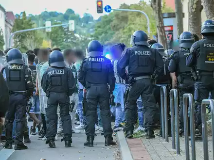 Eine Gruppe von Menschen wird nach Ausschreitungen bei einer Eritrea-Veranstaltung von Polizeikräften eingekesselt. - Foto: Jason Tschepljakow/dpa