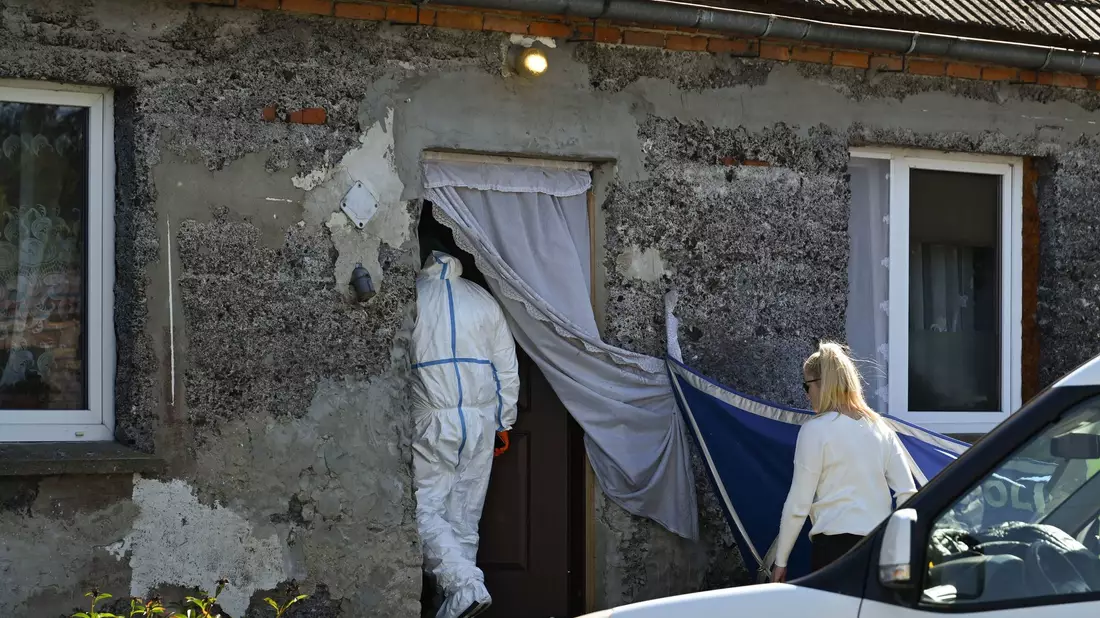 Ein Auto der Polizei steht während Ermittlungsarbeiten vor einem Familienhaus. - Bild: Adam Warzawa/PAP/dpa