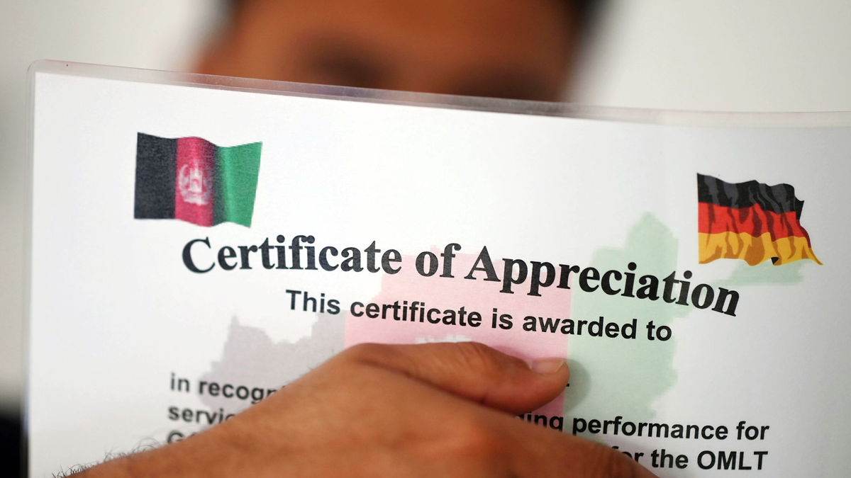 Ein geflüchteter Mann, der als afghanische Ortskraft tätig war, zeigt ein Zertifikat, das nach seinen eigenen Angaben die Zusammenarbeit mit der Bundeswehr in Afghanistan würdigt. - Foto: Uli Deck/dpa