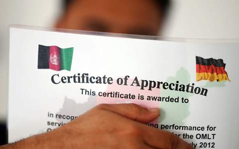 Ein geflüchteter Mann, der als afghanische Ortskraft tätig war, zeigt ein Zertifikat, das nach seinen eigenen Angaben die Zusammenarbeit mit der Bundeswehr in Afghanistan würdigt. - Foto: Uli Deck/dpa Ein geflüchteter Mann, der als afghanische Ortskraft tätig war, zeigt ein Zertifikat, das nach seinen eigenen Angaben die Zusammenarbeit mit der Bundeswehr in Afghanistan würdigt. - Foto: Uli Deck/dpa