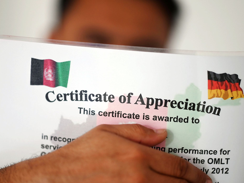 Ein geflüchteter Mann, der als afghanische Ortskraft tätig war, zeigt ein Zertifikat, das nach seinen eigenen Angaben die Zusammenarbeit mit der Bundeswehr in Afghanistan würdigt. - Foto: Uli Deck/dpa