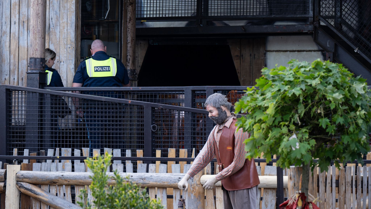 Polizisten untersuchen die Achterbahn auf dem Festgelände. - Foto: Sven Hoppe/dpa