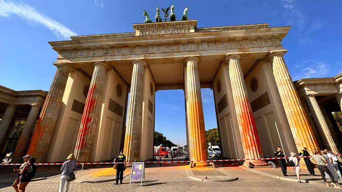 Mitglieder der Klimaschutzgruppe Letzte Generation haben das Brandenburger Tor in Berlin mit oranger Farbe angesprüht. - Bild: Paul Zinken/dpa