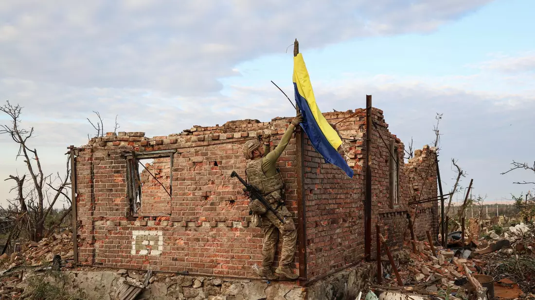 Ein ukrainischer Kommandeur hisst die Nationalflagge als Symbol der Befreiung des Frontdorfes Andrijewka in der Region Donezk. - Bild: Alex Babenko/AP/dpa
