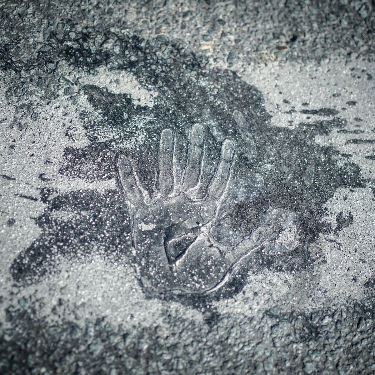 Handabdruck eines Aktivisten der Klimagruppe Letzte Generation auf der Straße am Großen Stern in Berlin. - Foto: Kay Nietfeld/dpa