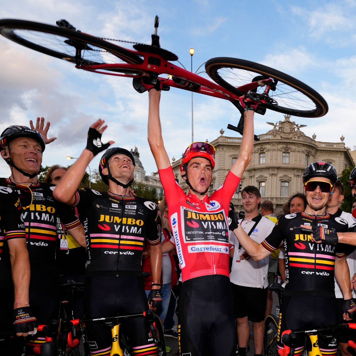 Sepp Kuss (M) stemmte im Ziel sein rot lackiertes Rad in die Höhe. - Foto: Manu Fernandez/AP/dpa