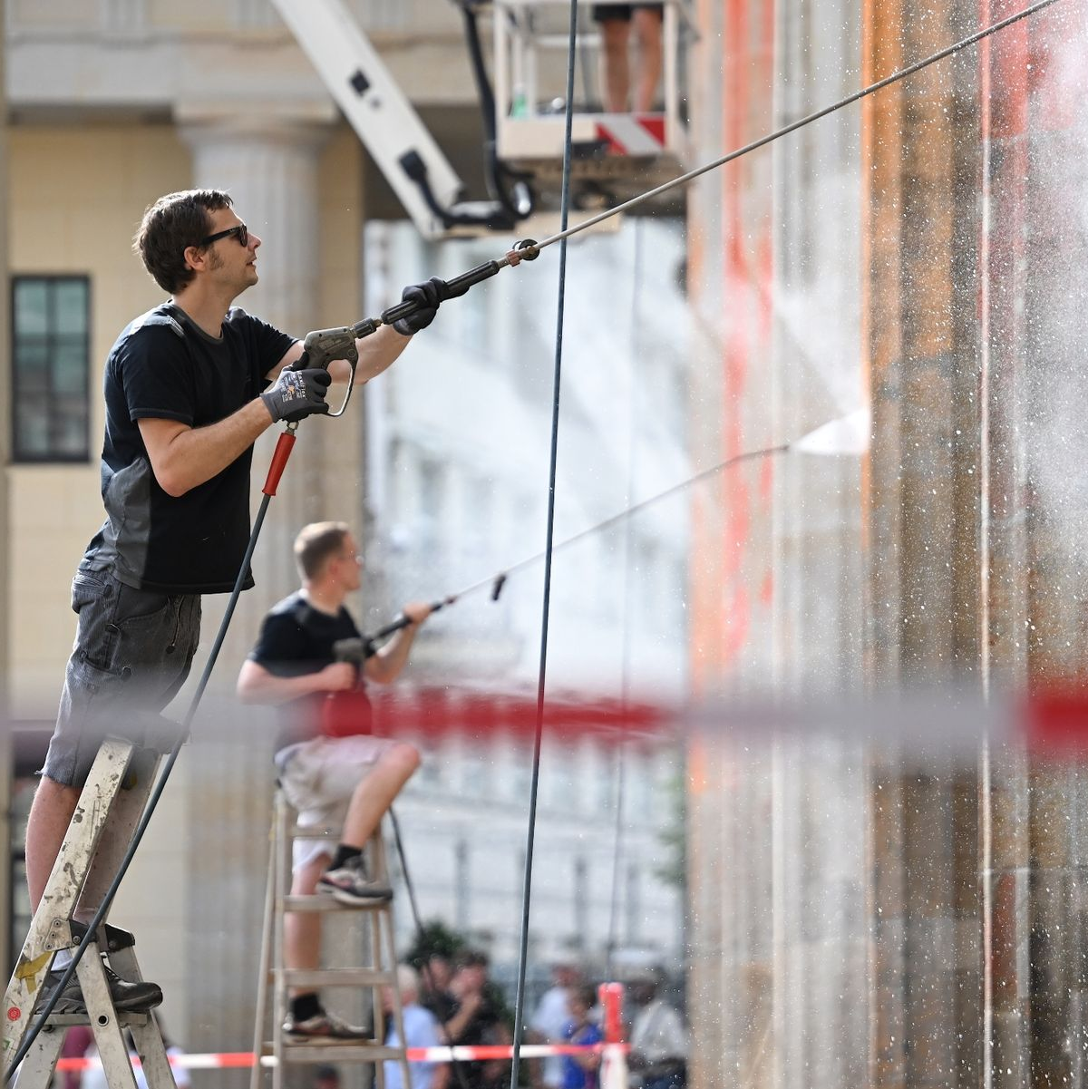Reinigungsarbeiten nach einem Farbanschlag der so genannten Letzten Generation auf das Brandenburger Tor. - Foto: Britta Pedersen/dpa