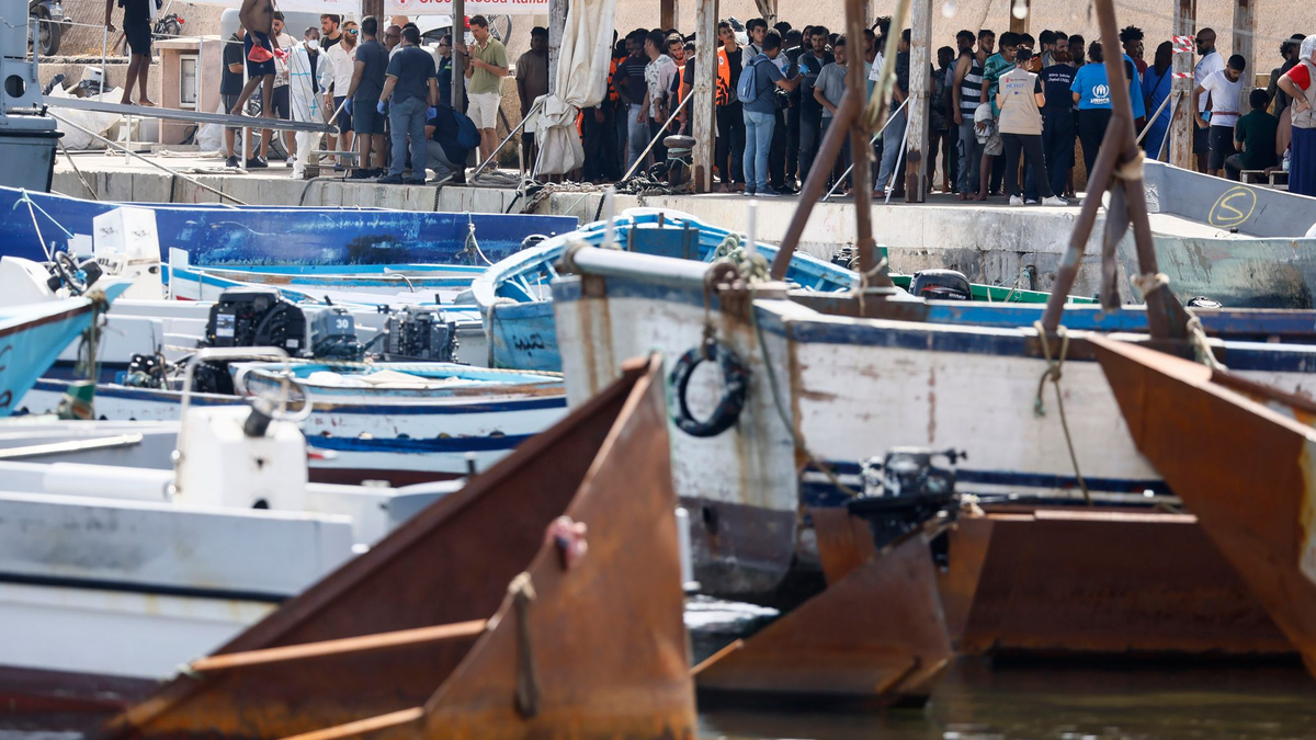 Migranten stehen an einem Hafen auf Lampedusa. - Foto: Cecilia Fabiano/LaPresse via ZUMA Press/dpa