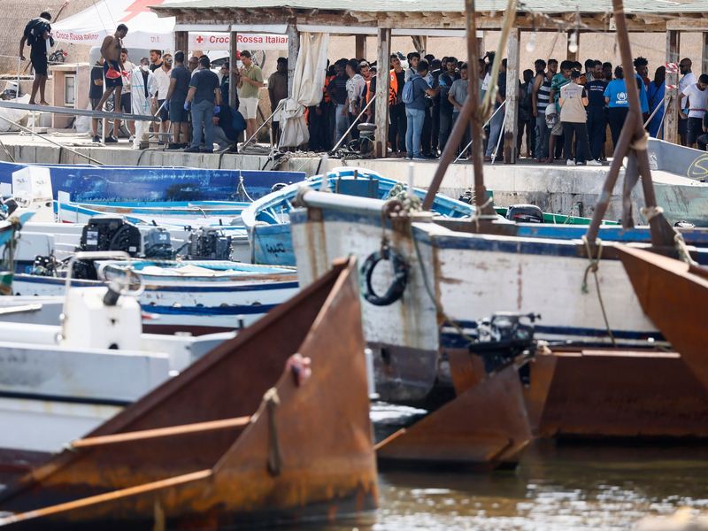 Migranten stehen an einem Hafen auf Lampedusa. - Foto: Cecilia Fabiano/LaPresse via ZUMA Press/dpa