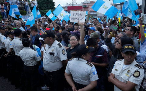 Während einer Demonstration in Guatemala-Stadt hält eine Frau ein Schild mit der Aufschrift «Parasiten raus» in die Höhe. Tausende Menschen protestieren in dem lateinamerikanischen Land gegen die Generalstaatsanwaltschaft. - Foto: Moises Castillo/AP/dpa