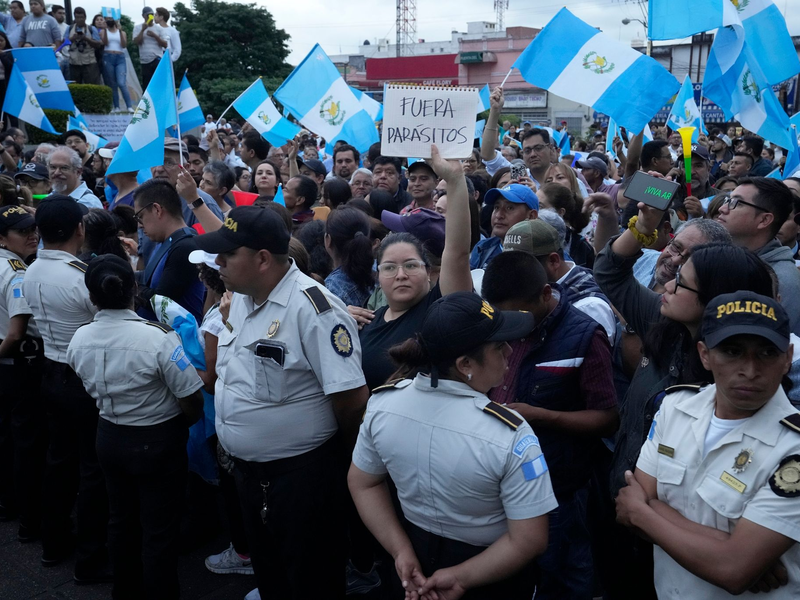Während einer Demonstration in Guatemala-Stadt hält eine Frau ein Schild mit der Aufschrift «Parasiten raus» in die Höhe. Tausende Menschen protestieren in dem lateinamerikanischen Land gegen die Generalstaatsanwaltschaft. - Foto: Moises Castillo/AP/dpa