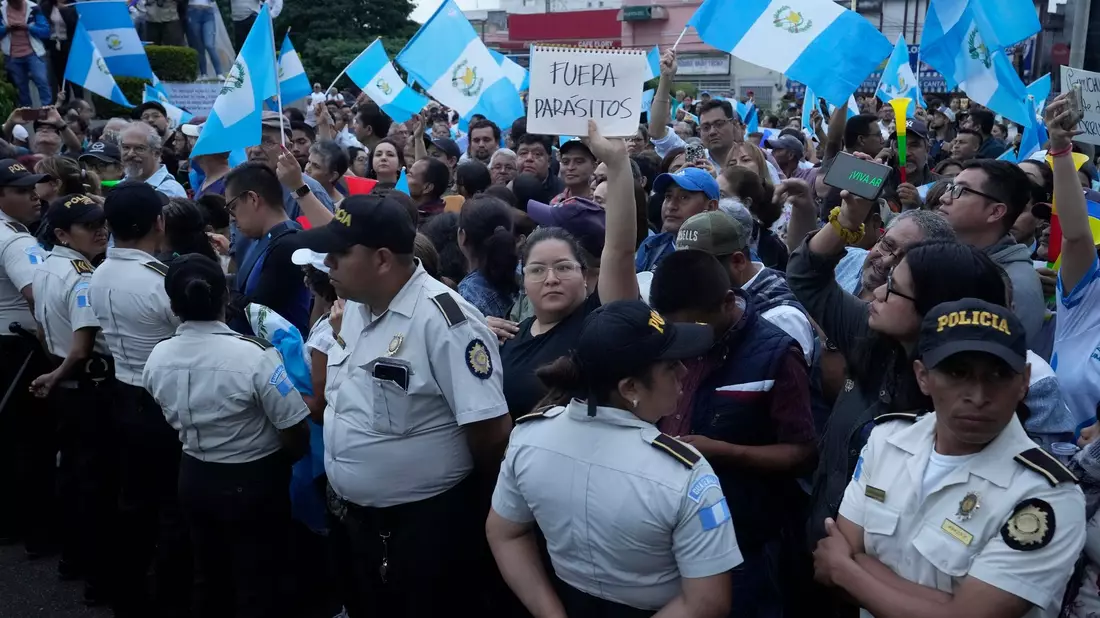 Während einer Demonstration in der Hauptstadt hält eine Frau ein Schild mit der Aufschrift «Parasiten raus» in die Höhe. Tausende Menschen protestieren in Guatemala gegen die Generalstaatsanwaltschaft. - Bild: Moises Castillo/AP/dpa