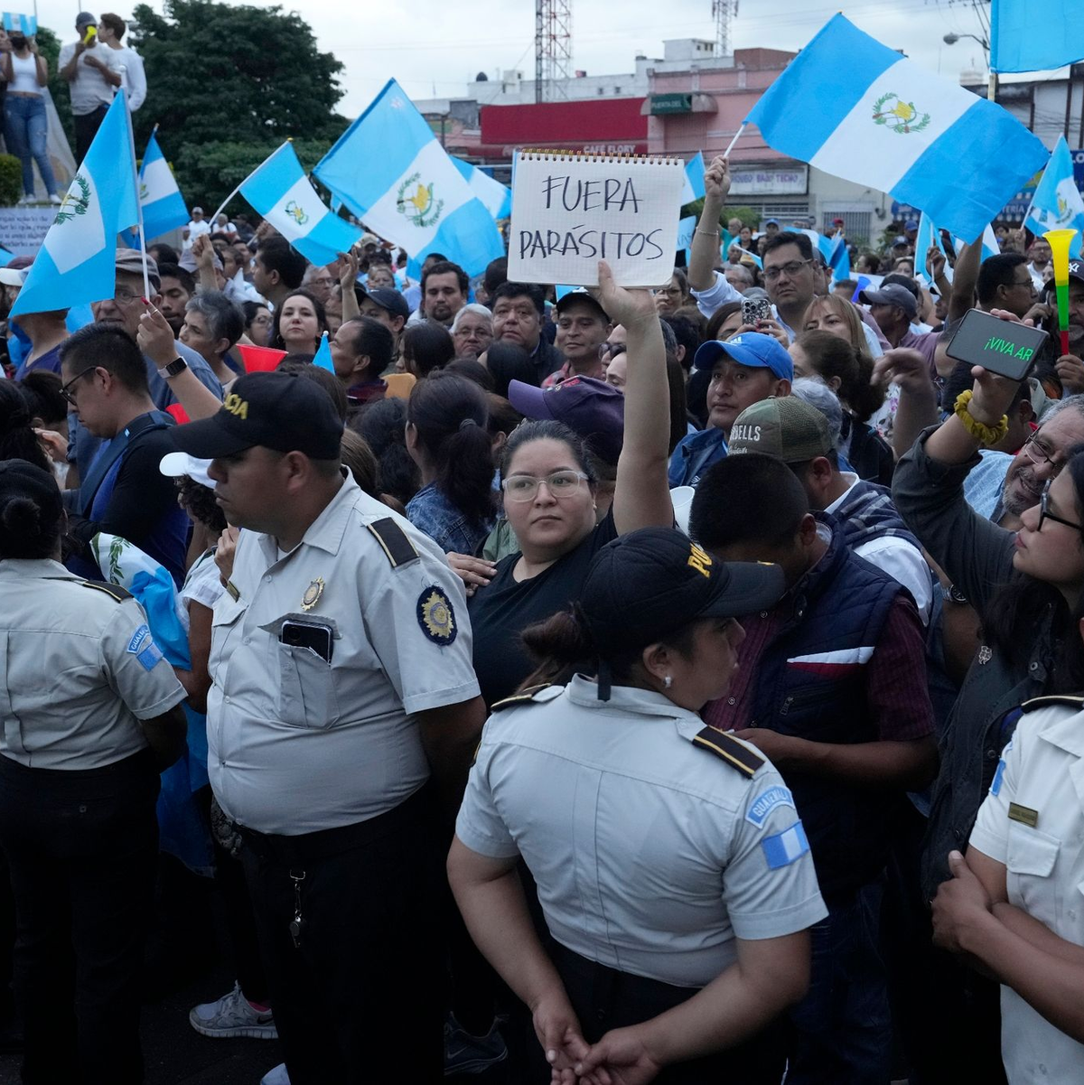 Während einer Demonstration in der Hauptstadt hält eine Frau ein Schild mit der Aufschrift «Parasiten raus» in die Höhe. Tausende Menschen protestieren in Guatemala gegen die Generalstaatsanwaltschaft. - Foto: Moises Castillo/AP/dpa