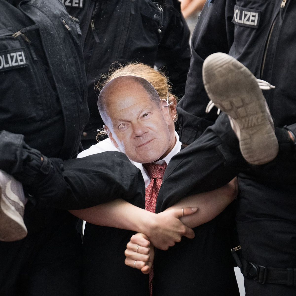 Polizisten tragen während eines Protestmarsches der Klimaschutzgruppe Letzte Generation eine Teilnehmerin von der Straße. - Foto: Sebastian Christoph Gollnow/dpa