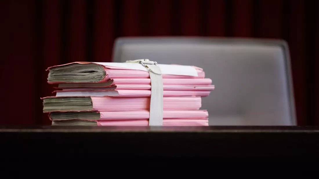 Prozessakten liegen im Schwurgerichtssaal 205 im Landgericht Paderborn, wo über eine Sicherungsverwahrung für Wilfried W. entschieden wird. - Bild: Friso Gentsch/dpa