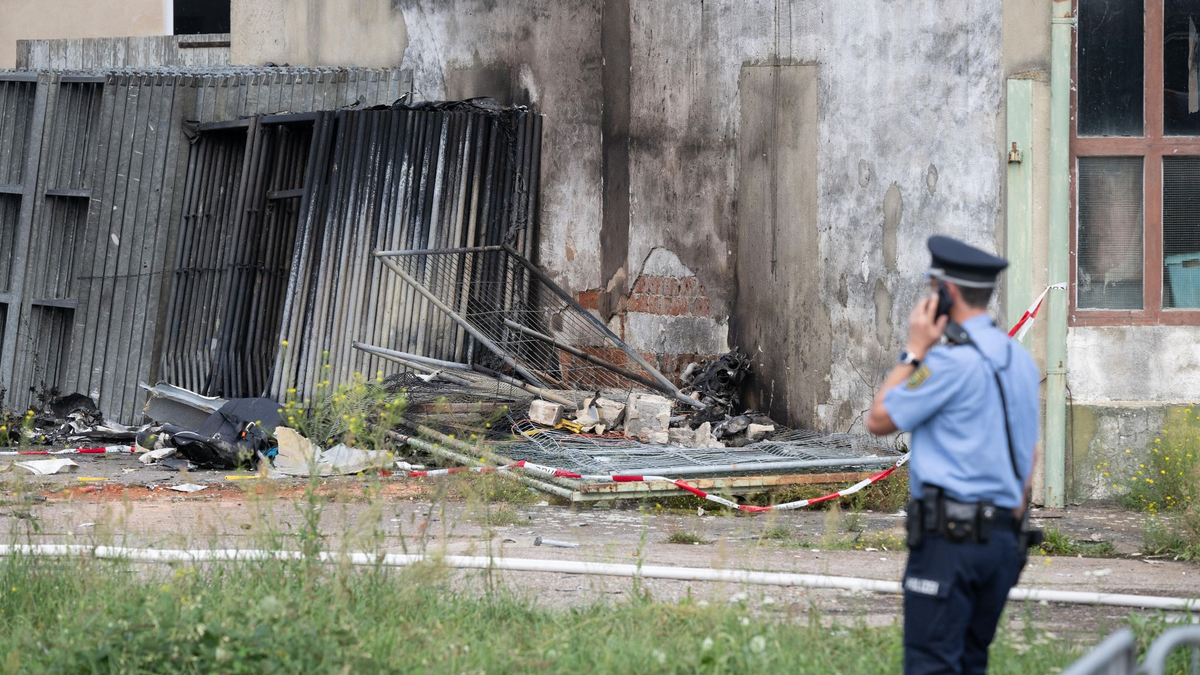 Ein Polizist steht nach dem Absturz vor den Wrackteilen des Kleinflugzeugs. - Foto: Sebastian Kahnert/dpa