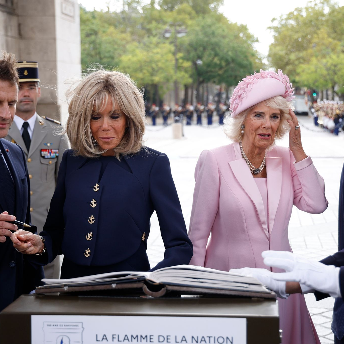 Präsident Emmanuel Macron (l-r) und und seine Ehefrau Brigitte Macron sowie Königin Camilla und König Charles III. von Großbritannien tragen sich während einer Zeremonie am Triumphbogen in Paris ins Goldene Buch ein. - Foto: Yoan Valat/EPA POOL/AP/dpa