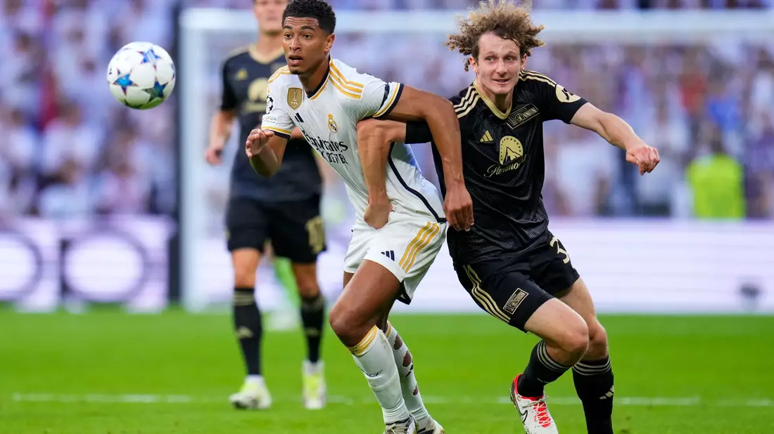 Real Madrids Jude Bellingham (l) und Unions Alex Kral im Zweikampf. - Bild: Manu Fernandez/AP