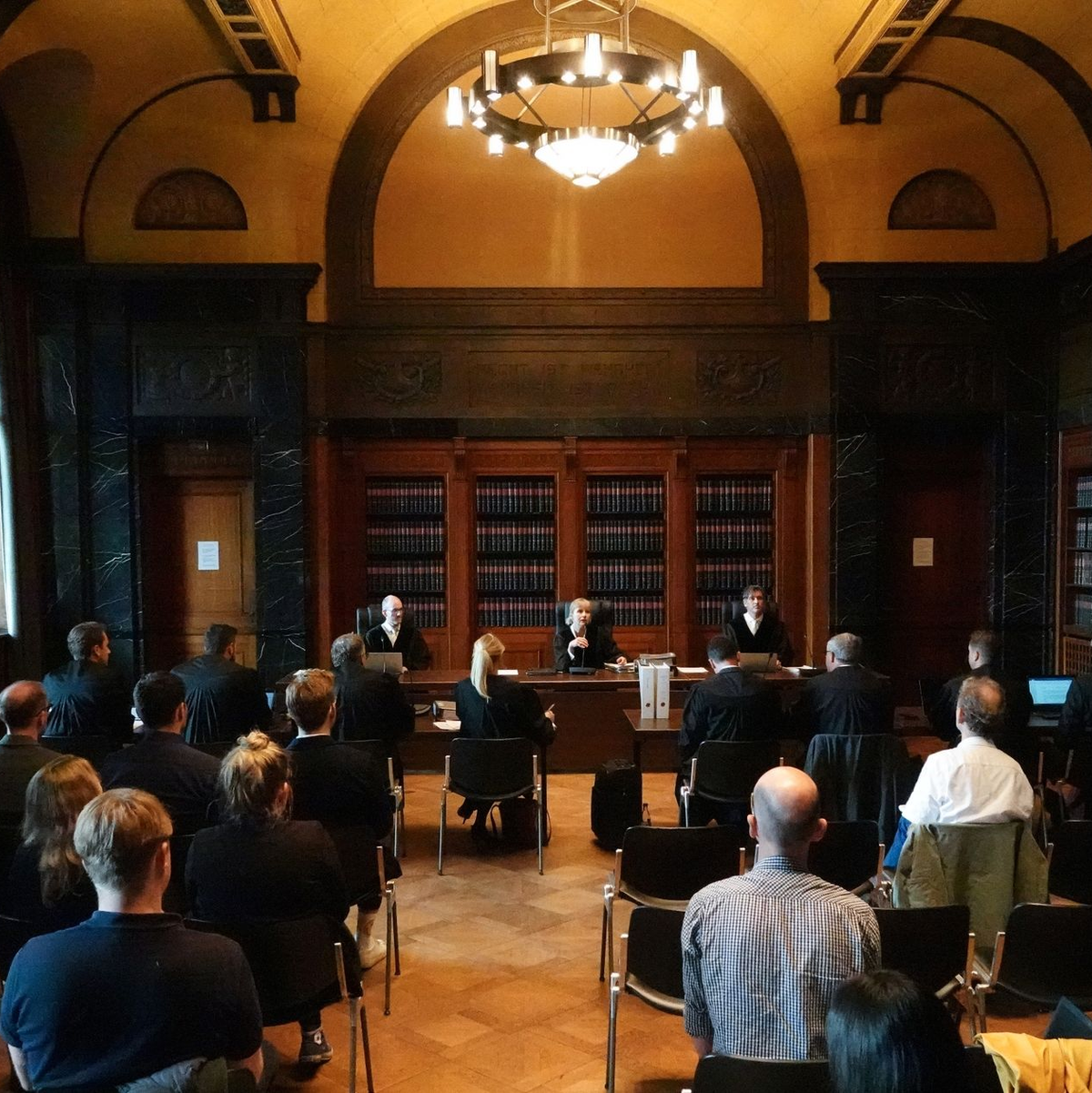 Stephanie Zöllner (hinten, M), Vorsitzende Richterin am Hanseatischen Oberlandesgericht, und weitere Verhandlungsbeteiligte zu Beginn der mündlichen Verhandlung zur Musterfeststellungsklage gegen Parship. - Foto: Franziska Spiecker/dpa