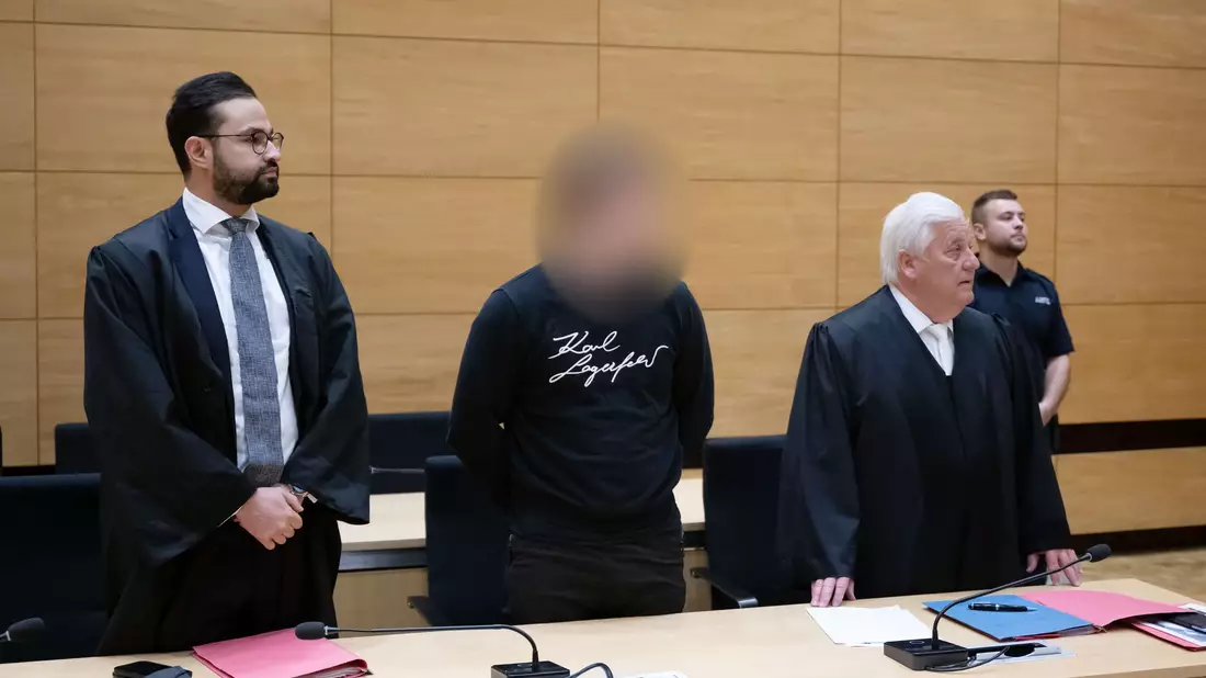 Der Angeklagte (M) und seine Verteidiger im Gerichtssaal im Landgericht Bielefeld. - Bild: Bernd Thissen/dpa