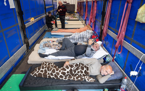 Trucker aus Georgien liegen auf einem Matratzenlager auf der Ladefläche eines Lkw. Sie sind in einen Hungerstreik getreten. - Foto: Boris Roessler/dpa