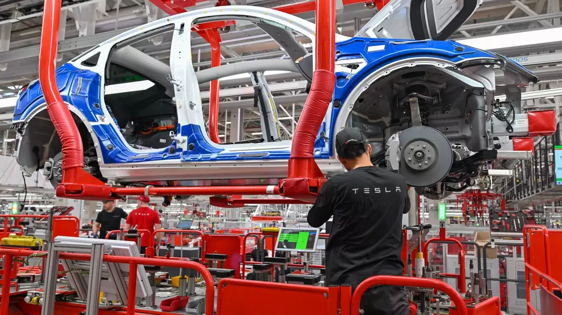 Ein Mitarbeiter der Tesla Gigafactory in Brandenburg. Der Autobauer hat dem Land ein starkes Wachstum beschert. - Bild: Patrick Pleul/dpa