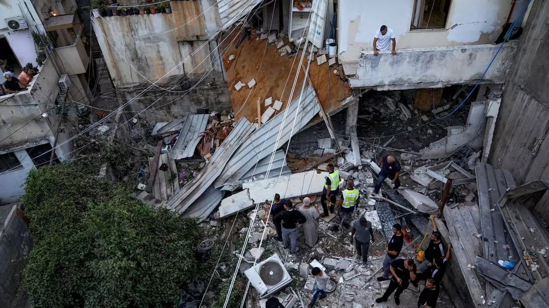 Palästinenser inspizieren nach dem Einsatz der israelischen Armee ein beschädigtes Gebäude. - Bild: Majdi Mohammed/AP
