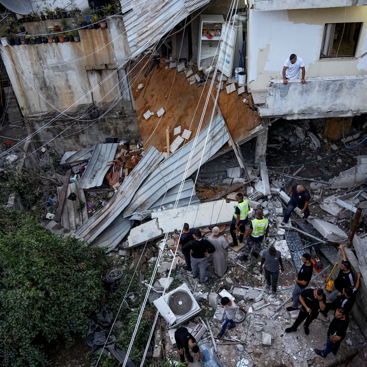 Palästinenser inspizieren nach dem Einsatz der israelischen Armee ein beschädigtes Gebäude. - Foto: Majdi Mohammed/AP