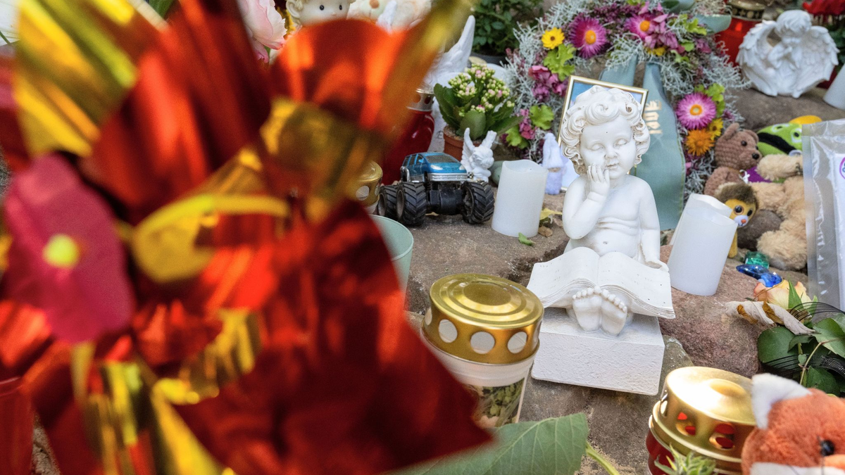 Neben einem Fußballfeld an einem See in Pragsdorf, dem möglichen Tatort, sind Kerzen, Plüschtiere und Fotos abgelegt. - Foto: Stefan Sauer/dpa