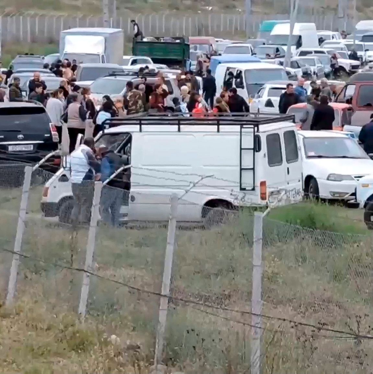 Geflüchtete Menschen versammeln sich in einem von russischen Friedenstruppen errichteten Auffanglager bei Stepanakert in Berg-Karabach (Videostandbild vom 21.09.2023). - Foto: Uncredited/Russian Defense Ministry Press Service/AP
