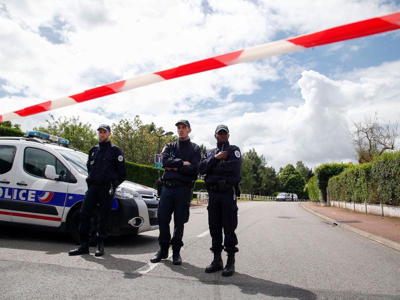 Beamte stehen 2016 am Tatort in Magnanville bei Paris. - Foto: Thibault Camus/AP/dpa